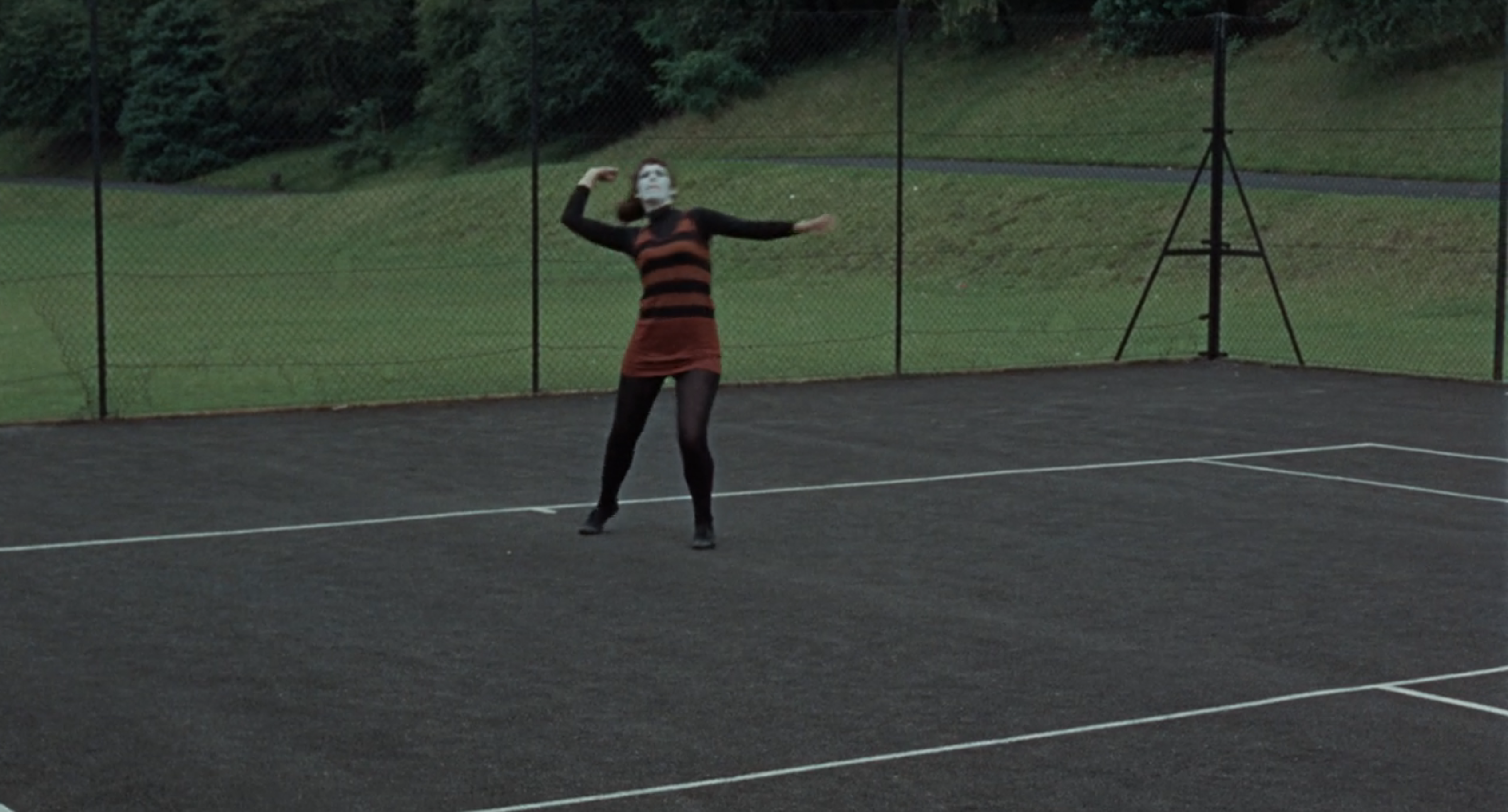 a mime serving a tennis ball